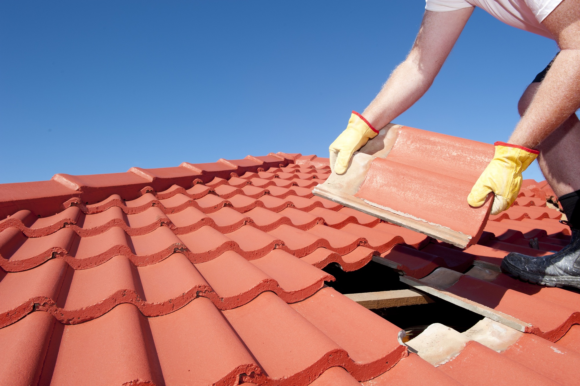 Roofing crew replacing worn shingles on an occupied home in a quiet residential neighborhood