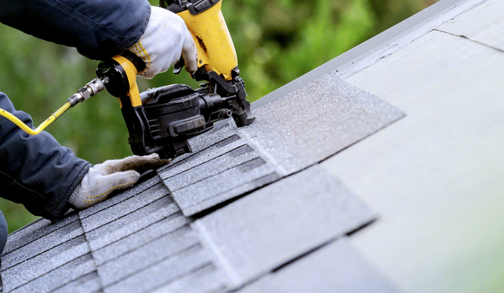 Experienced roofer inspecting roof edges, vents, and drainage areas during scheduled maintenance